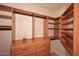Well-organized walk-in closet with wood shelving, drawers, and hanging rods providing ample storage at 5350 E Deer Valley Dr # 2435, Phoenix, AZ 85054