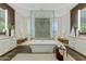 Beautiful primary bathroom featuring dual vanities, soaking tub, and large glass enclosed shower at 5527 E Arroyo Verde Dr, Paradise Valley, AZ 85253