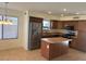 A modern kitchen featuring stainless steel appliances, wood cabinets and a center island at 56 W Holstein Trl, San Tan Valley, AZ 85143