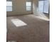Spacious living room area featuring plush carpeting and sunlit windows at 56 W Holstein Trl, San Tan Valley, AZ 85143