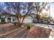 Inviting home with a two-car garage, desert landscaping, and a large tree at 6331 W Winslow Ave, Phoenix, AZ 85043