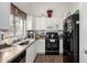 A well-lit kitchen featuring white cabinetry, dark countertops, and modern appliances at 6331 W Winslow Ave, Phoenix, AZ 85043