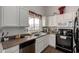 Well-lit kitchen featuring white cabinetry, dark countertops, and modern appliances at 6331 W Winslow Ave, Phoenix, AZ 85043