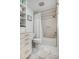 A clean, white bathroom features a shower-tub combo, marble floors and a convenient shelving unit at 6801 E Sheena Dr, Scottsdale, AZ 85254