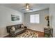 A simple guest bedroom is nicely furnished with a gray futon, small accent table and lovely artwork at 6801 E Sheena Dr, Scottsdale, AZ 85254