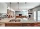 Open-concept kitchen with granite island and a view of the living room and fireplace with light-colored brick at 6801 E Sheena Dr, Scottsdale, AZ 85254