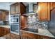 A modern kitchen boasts stainless steel appliances and beautiful granite countertops with dark wooden cabinetry at 6801 E Sheena Dr, Scottsdale, AZ 85254