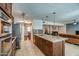 Open floor plan with kitchen including granite countertops, stainless appliances, and bar stool seating at 6801 E Sheena Dr, Scottsdale, AZ 85254