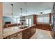 Spacious kitchen with granite island, stainless steel appliances and view of the living room and fireplace at 6801 E Sheena Dr, Scottsdale, AZ 85254