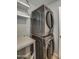 A silver, stacked Samsung washer and dryer set with open shelving in a well-lit laundry room at 6801 E Sheena Dr, Scottsdale, AZ 85254