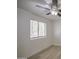 Bedroom with a ceiling fan, a large window with blinds, and light-colored, wood-look flooring at 7135 E Baywood Ave, Mesa, AZ 85208