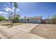 Single-story home with palm trees, a manicured lawn, and a driveway leading to the front entrance at 7135 E Baywood Ave, Mesa, AZ 85208