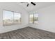 Bright bedroom with wood-look floors, ceiling fan, and large windows at 7230 N 70Th Ln, Glendale, AZ 85303