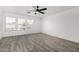 Spacious bedroom with hardwood flooring, ceiling fan, and three windows at 7230 N 70Th Ln, Glendale, AZ 85303