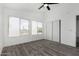 Bedroom featuring wood-look floors, two windows, a ceiling fan, and a closet at 7230 N 70Th Ln, Glendale, AZ 85303