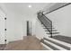 Entryway showcases new vinyl plank flooring, a black staircase and a view into another room at 7230 N 70Th Ln, Glendale, AZ 85303