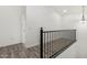 Hallway with hardwood flooring and black iron railing at 7230 N 70Th Ln, Glendale, AZ 85303