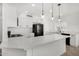 Modern kitchen with white cabinets, quartz countertops, and black appliances at 7230 N 70Th Ln, Glendale, AZ 85303