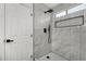 Modern shower with marble-look tile, rainfall showerhead, handheld sprayer and decorative inset at 7230 N 70Th Ln, Glendale, AZ 85303