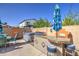 Outdoor kitchen area with a built-in grill, bar seating, and a relaxing hot tub for outdoor enjoyment at 737 W Desert Valley Dr, San Tan Valley, AZ 85143