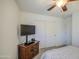 Bedroom with a ceiling fan, closet, and TV, offering a comfortable and functional living space at 737 W Desert Valley Dr, San Tan Valley, AZ 85143