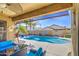 Inviting backyard oasis with a refreshing pool, covered patio, and lush landscaping for relaxation and entertainment at 737 W Desert Valley Dr, San Tan Valley, AZ 85143