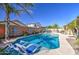 Beautiful backyard with a sparkling pool, lounge chairs, and mature landscaping, perfect for outdoor living at 737 W Desert Valley Dr, San Tan Valley, AZ 85143