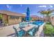Relaxing backyard pool area with an outdoor dining set under a colorful umbrella, perfect for summer days at 737 W Desert Valley Dr, San Tan Valley, AZ 85143
