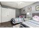 Inviting bedroom featuring twin beds, complemented by framed art and a double-door closet at 7402 W Kerry Way, Glendale, AZ 85308