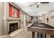 Game room with fireplace, pool table, kitchen with bar seating in open concept design at 7402 W Kerry Way, Glendale, AZ 85308