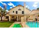 Backyard view of a sparkling pool, patio with outdoor seating, and a charming two-story home under a blue sky at 7402 W Kerry Way, Glendale, AZ 85308