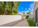 This backyard includes a view of the gate to the yard, a stucco wall and lush greenery at 7467 E Pleasant Run, Scottsdale, AZ 85258