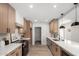 Modern kitchen featuring stainless steel appliances, white countertops, and natural wood cabinetry at 7467 E Pleasant Run, Scottsdale, AZ 85258
