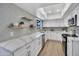 Bright kitchen featuring white cabinets, stainless appliances, grey backsplash, and floating shelves at 7826 N 21St Ln, Phoenix, AZ 85021