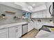 Bright kitchen featuring white cabinets, stainless appliances, grey backsplash, and floating shelves at 7826 N 21St Ln, Phoenix, AZ 85021