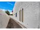 Neutral colored stucco wall in side walkway with accent windows and desert landscaping at 7826 N 21St Ln, Phoenix, AZ 85021