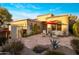 Beautiful home featuring a tiled roof, stone patio, iron gate, and lush desert landscaping at 7979 E Princess Dr # 26, Scottsdale, AZ 85255