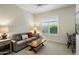 Cozy room with neutral colored walls, gray couch, and a table in front of a window at 7979 E Princess Dr # 26, Scottsdale, AZ 85255