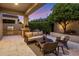 A cozy covered patio with comfortable seating, an outdoor grill, and lush green landscaping at 7979 E Princess Dr # 26, Scottsdale, AZ 85255