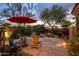 Paver patio featuring two chairs, a table, and a large red umbrella surrounded by beautiful desert landscaping at 7979 E Princess Dr # 26, Scottsdale, AZ 85255