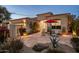 Inviting front patio with flagstone, seating, desert landscaping, and charming architectural lighting at twilight at 7979 E Princess Dr # 26, Scottsdale, AZ 85255