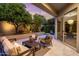 Covered patio with plush seating, landscaping, and a sliding glass door for easy indoor-outdoor living at 7979 E Princess Dr # 26, Scottsdale, AZ 85255