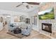 An open-concept living room with a fireplace, ceiling fan, and stylish furnishings at 8235 E Sierra Pinta Dr, Scottsdale, AZ 85255