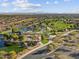 Expansive aerial view of the community with lush green spaces, a lake, and a playground at 8577 W Trenton Ct, Florence, AZ 85132