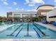 Large community swimming pool with lap lanes and a modern recreation center building at 8577 W Trenton Ct, Florence, AZ 85132