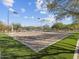 Sand volleyball court ready for a game under the bright sky, surrounded by lush greenery at 8577 W Trenton Ct, Florence, AZ 85132