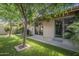 Backyard with mature trees, grassy area, a covered patio, and outdoor access through sliding glass doors at 945 N Pasadena -- # 84, Mesa, AZ 85201