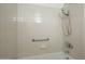 Detail of accessible tiled shower-tub combination with grab bar and chrome showerhead at 945 N Pasadena -- # 84, Mesa, AZ 85201