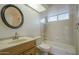 Bright bathroom featuring a round mirror, tiled shower-tub combination, and a wood vanity at 945 N Pasadena -- # 84, Mesa, AZ 85201