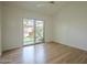 Spacious bedroom with wood floors, ceiling fan, and sliding glass door to private backyard with blooming flowers at 945 N Pasadena -- # 84, Mesa, AZ 85201